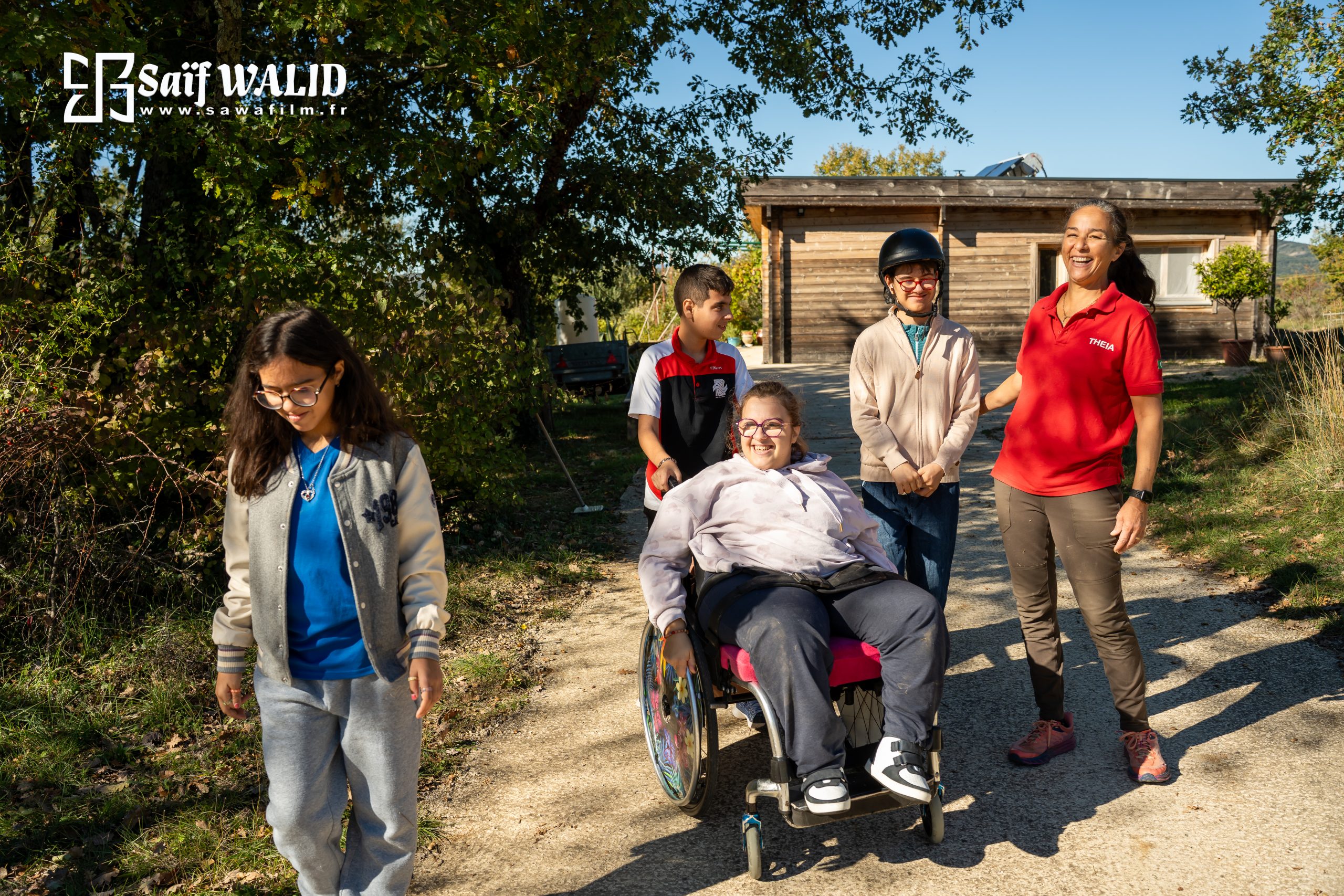 Groupe de jeunes personnes souriantes avec monitrice spécialisée en promenade au mas de rivet à Barjac