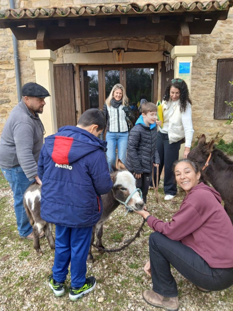 Photo de l'accueil des enfants et parents pour un atelier avec la présence des ânons, devant la porte d'entrée du Mas de Rivet à Barjac.
